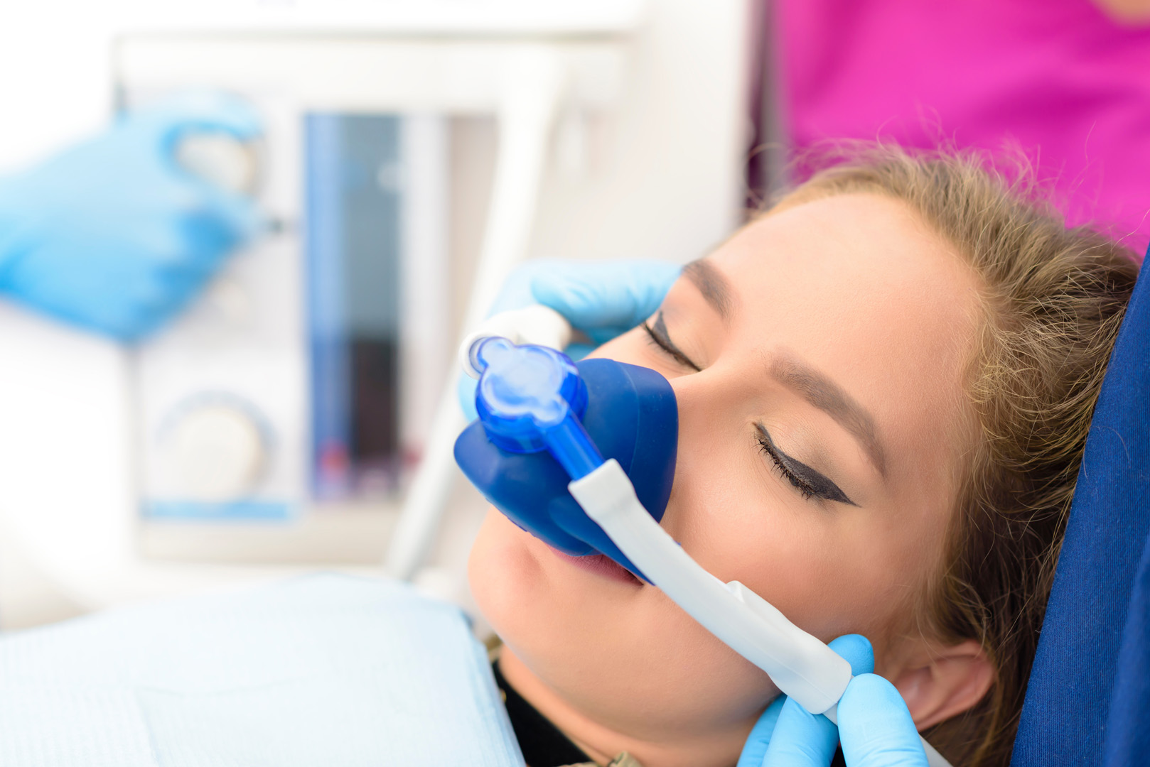 A relaxed patient wearing a nitrous oxide nose mask in the dental chair